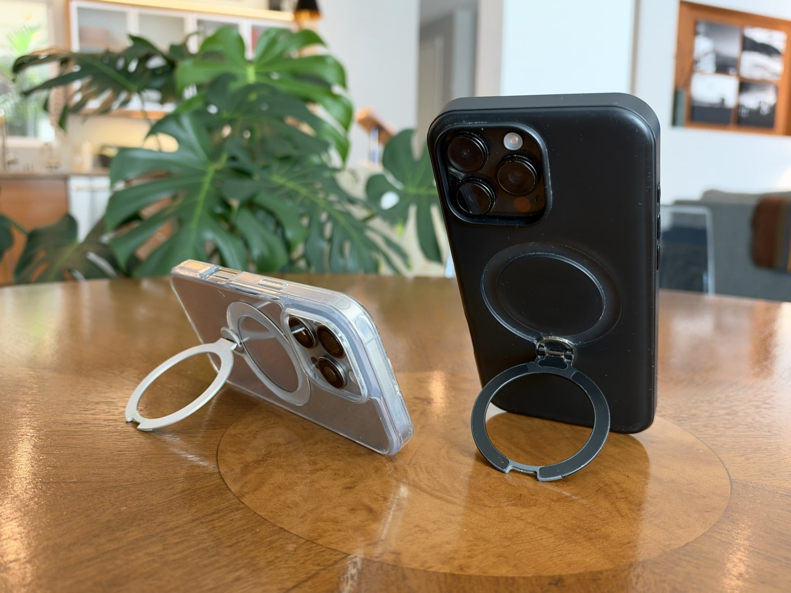 Clear iPhone 16 Pro case propped horizontally and black iPhone 16 Pro Max case propped vertically on their circular kickstands.