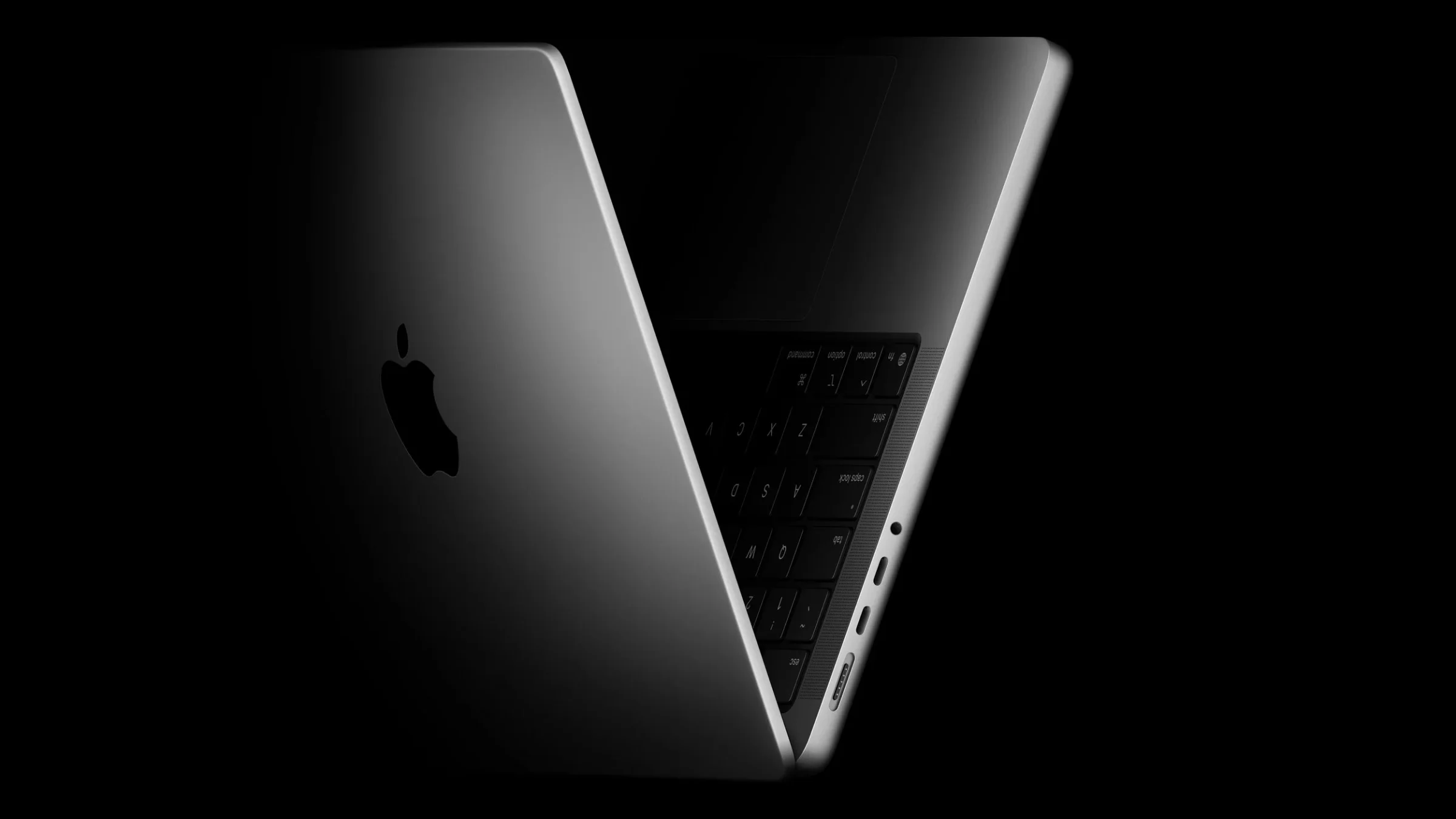 Two dark MacBook Pro computers shown partially open