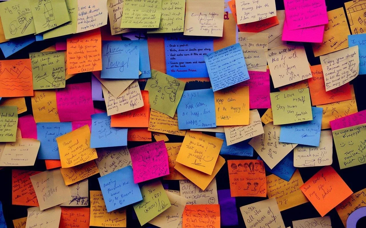 Wall covered with overlapping colorful sticky notes