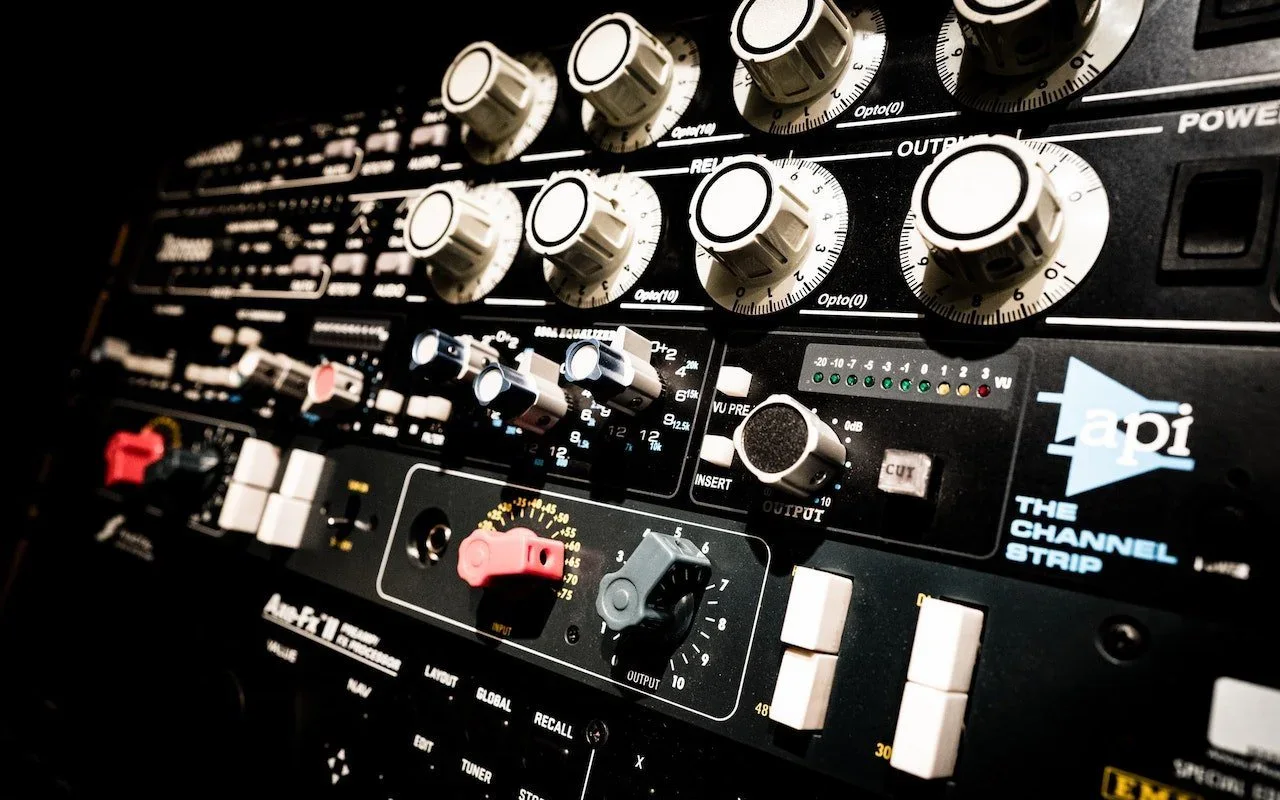 A professional audio mixing console covered with knobs and switches