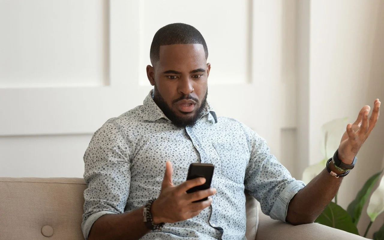 A frustrated man looking at his phone during a failed call
