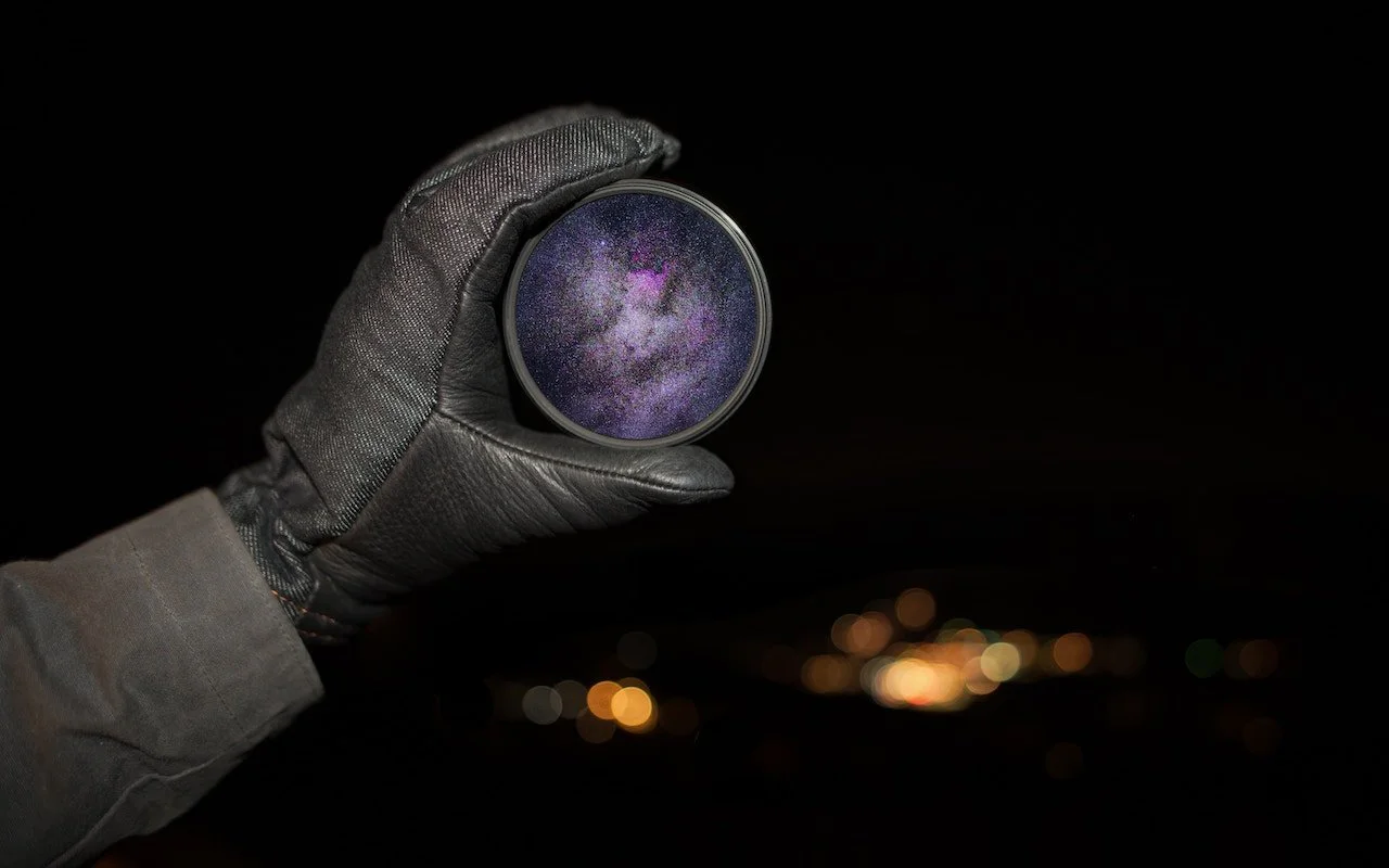 A person looking through a telescope at night