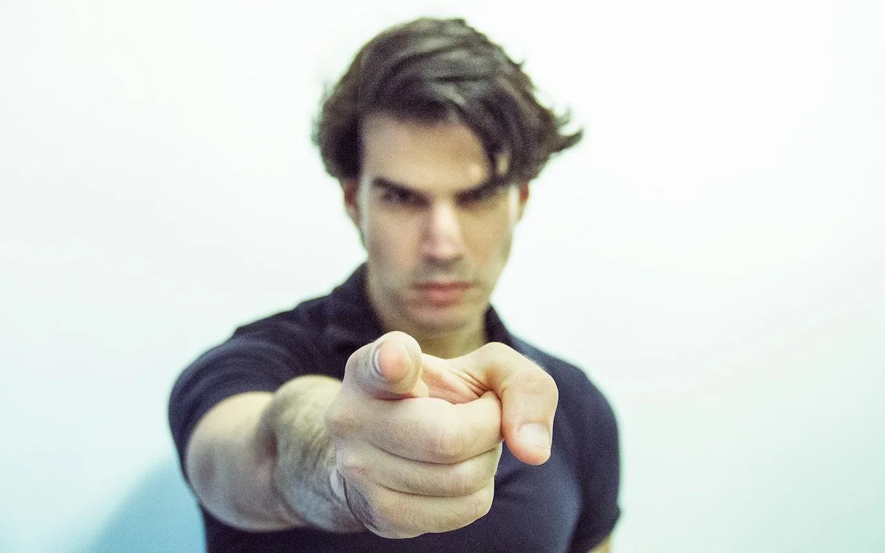 Person pointing directly toward the camera