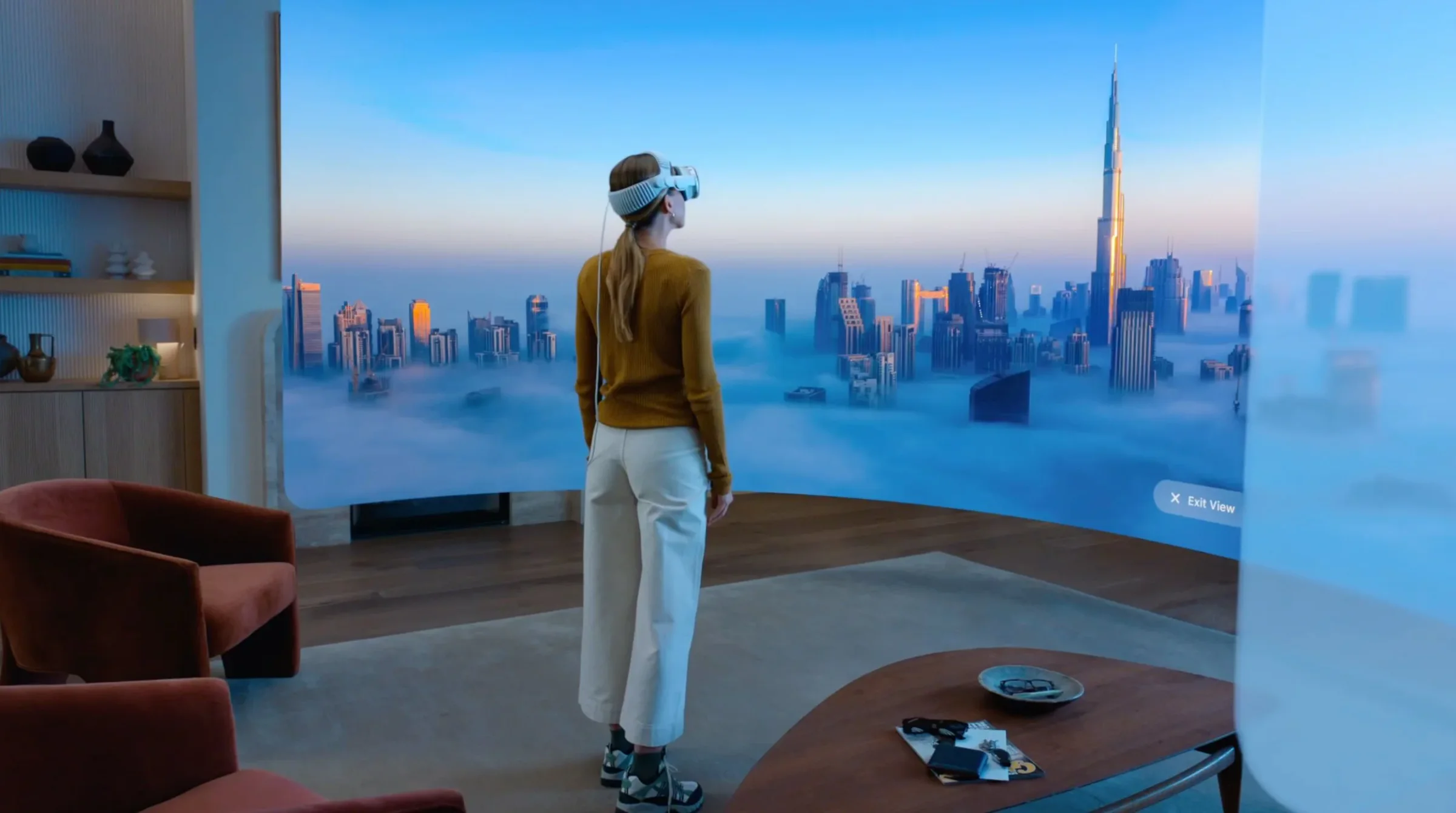 Person wearing Apple Vision Pro in a room overlooking a city skyline