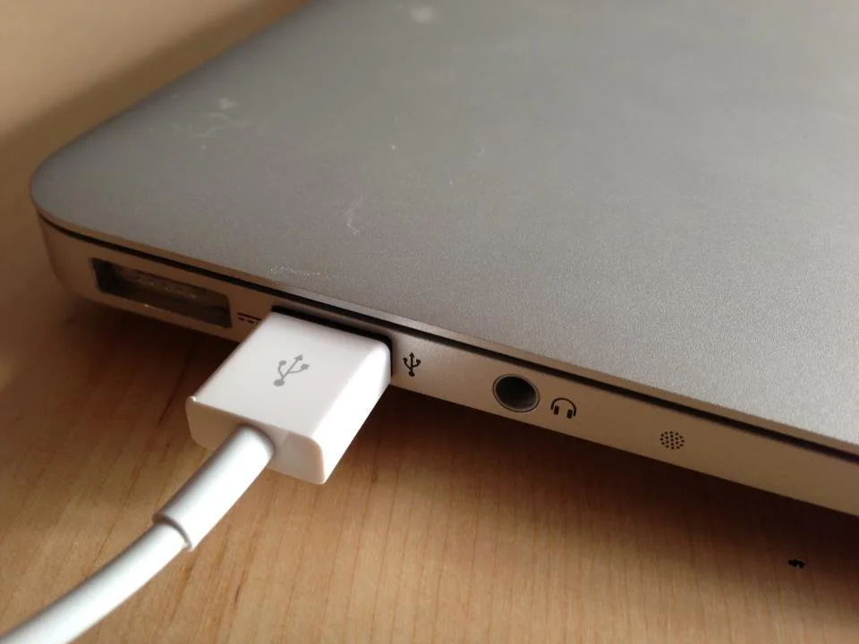 A charging cable connected to the side of a MacBook