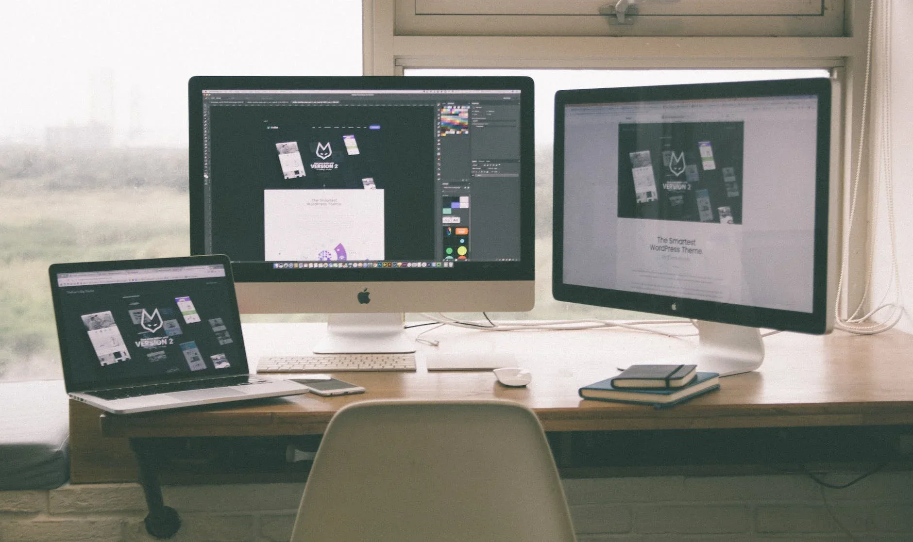 Desk with a MacBook and two external displays showing the same workspace