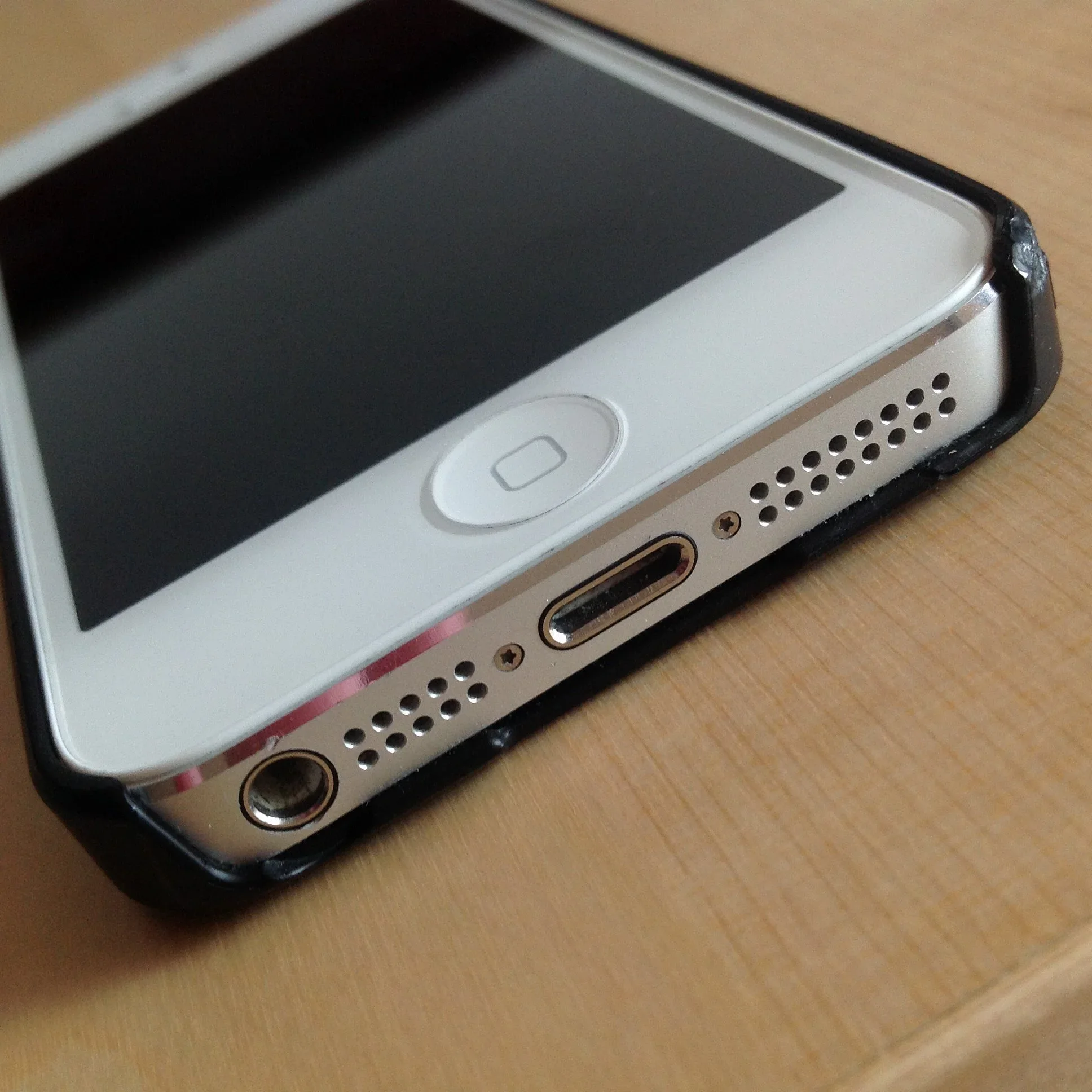 Close-up of the Lightning port and speaker openings on the bottom of an iPhone