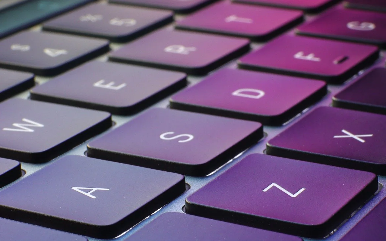 Close-up of a keyboard lit with purple and blue light