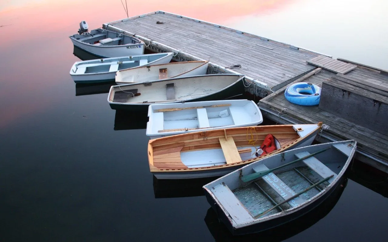 Small boats tied along the side of a wooden dock