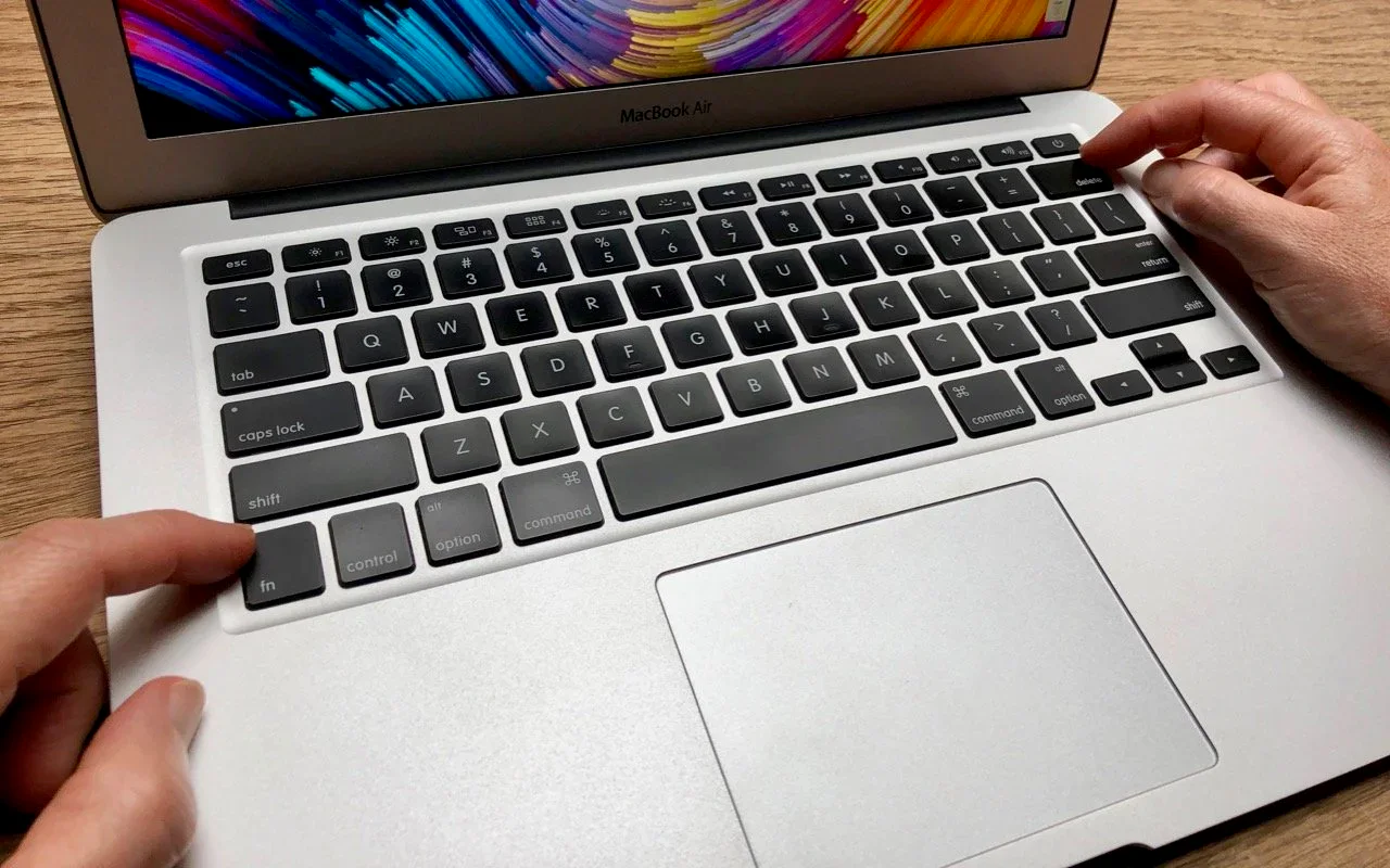 Hands using the keyboard and trackpad on a MacBook