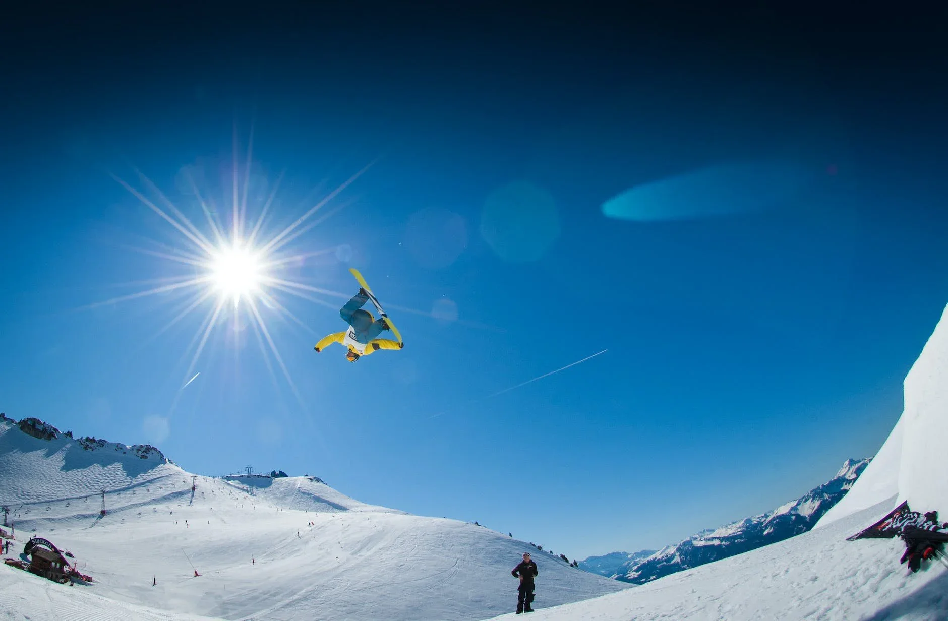 Skier soaring through the air above a snowy mountain