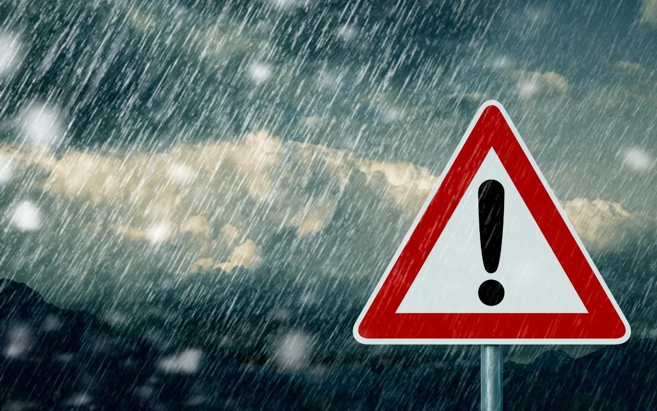 Heavy rain behind a warning sign