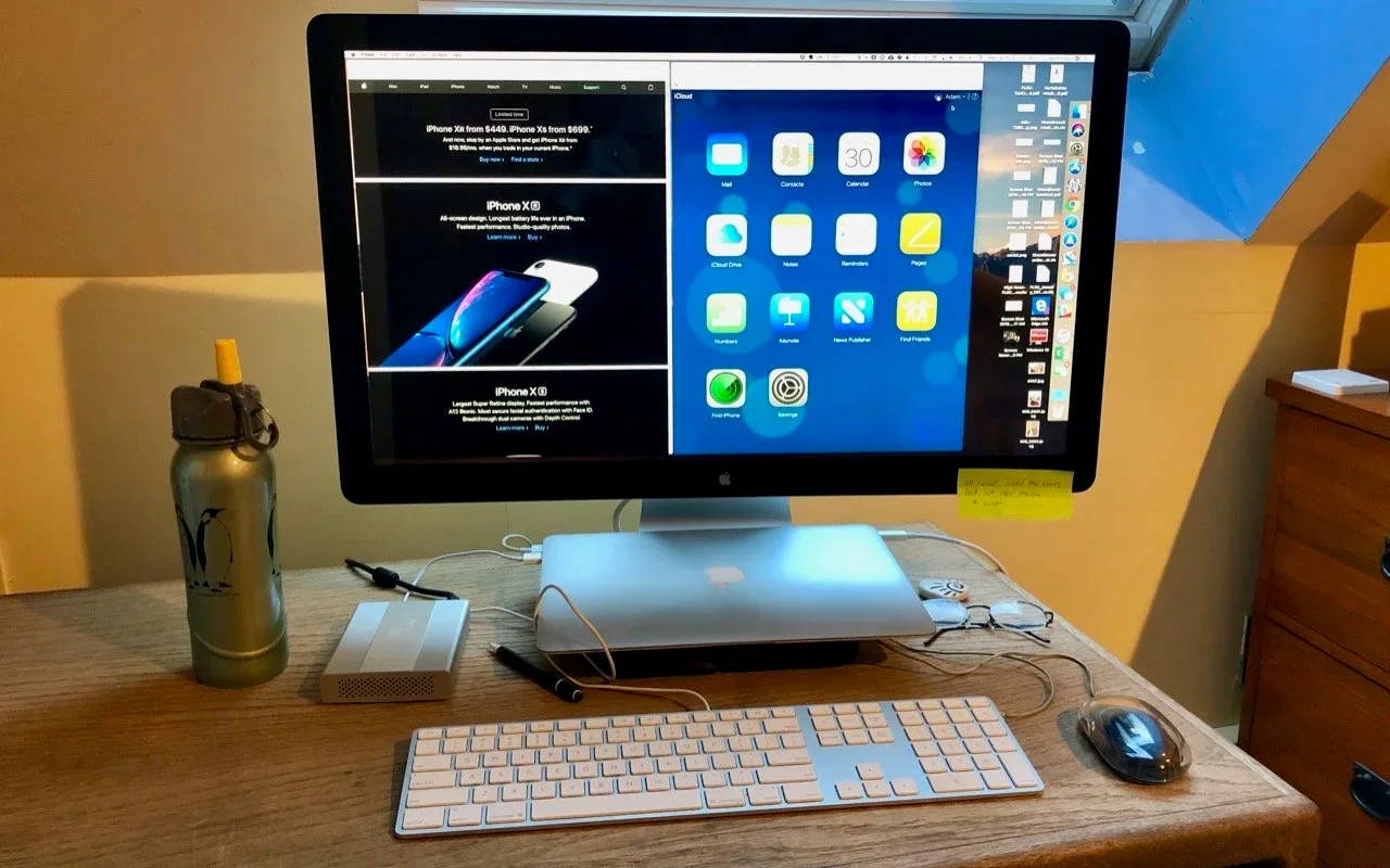 Closed MacBook connected to an external display, keyboard, and mouse