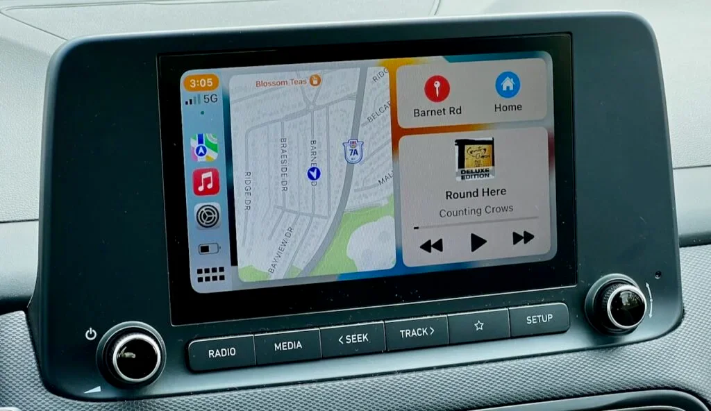 Apple CarPlay dashboard showing Maps, Music, and upcoming directions