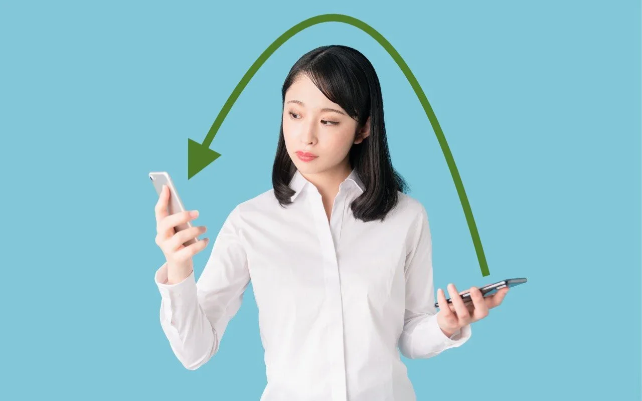 A person holding two iPhones with an arrow indicating a transfer between them